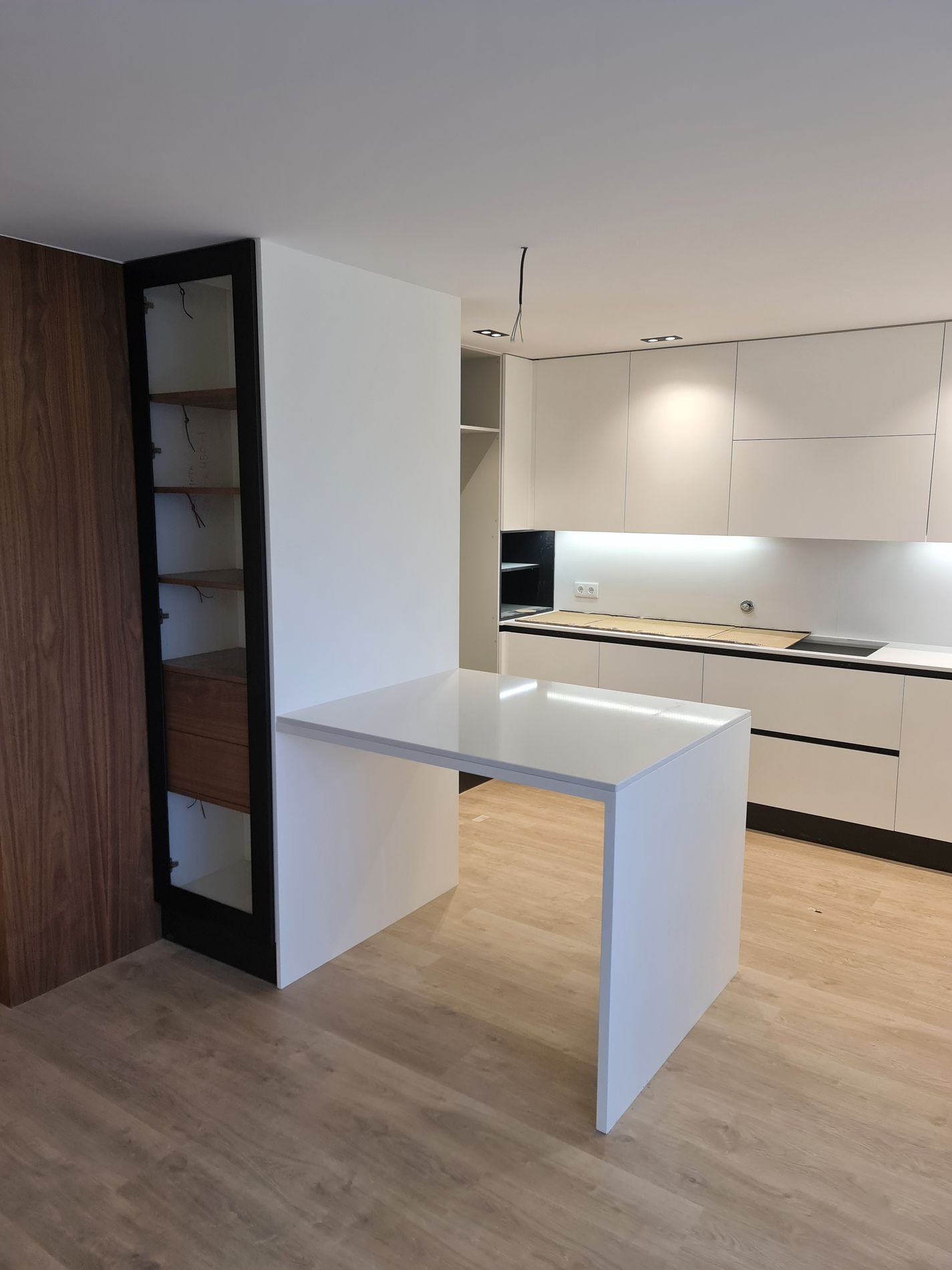 Mesa integrada em compacto branco junto a vitrine em nogueira